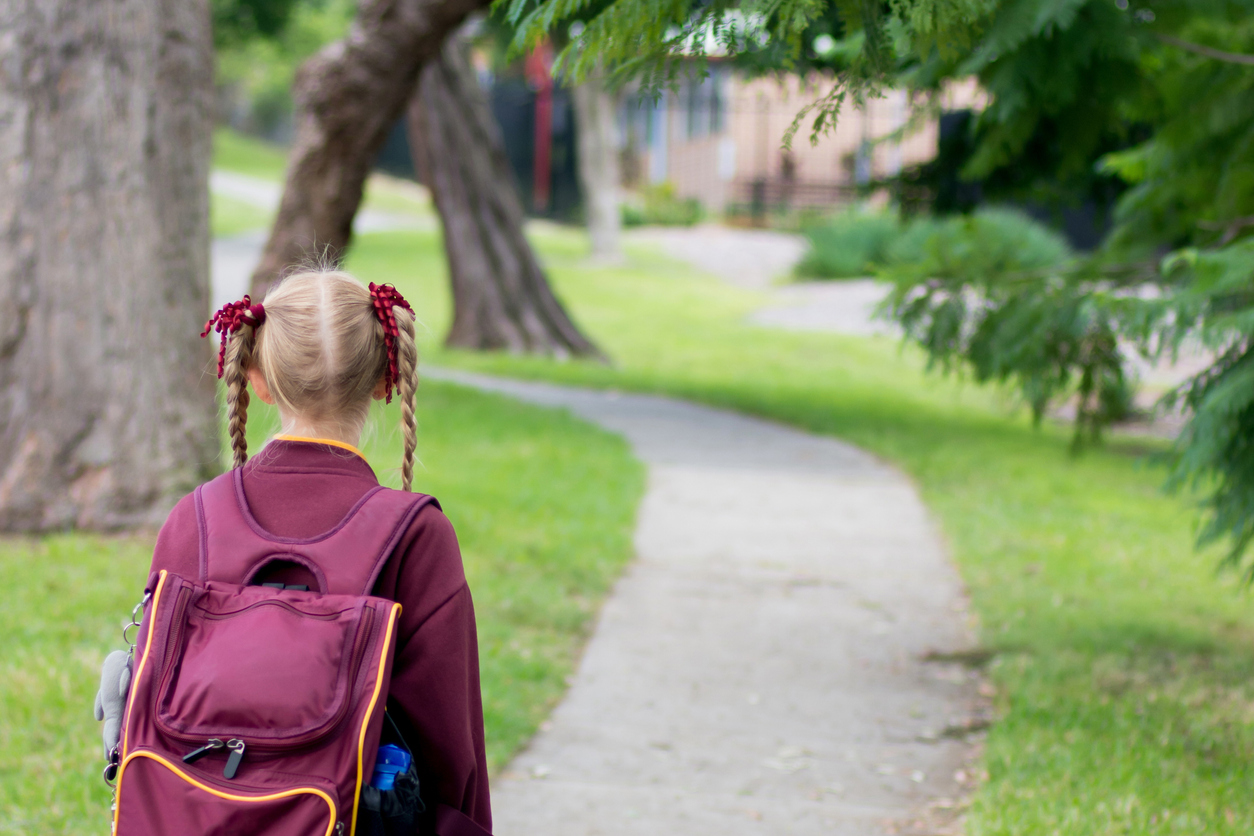 An Australian girl wearing a maroon school uniform.